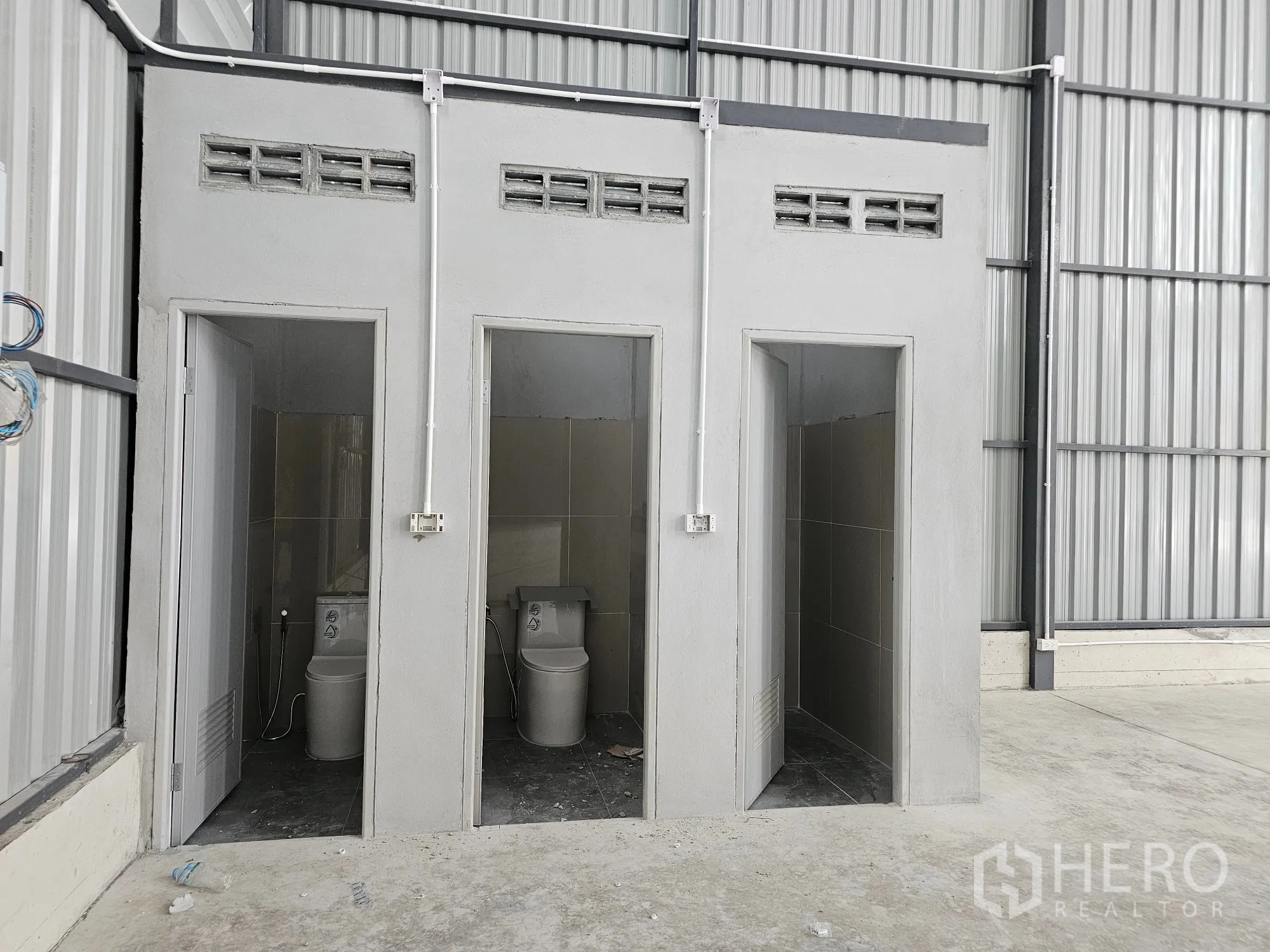 仓库 for rent in Bang Khen, Bangkok - 仓库内三间并排的卫生间隔间。