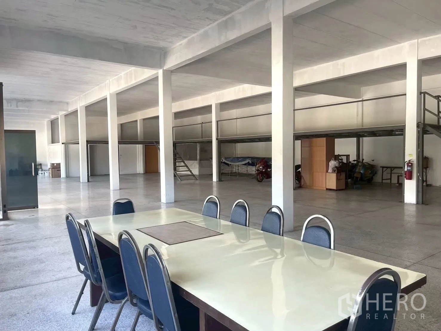工厂 for sale in Lat Krabang, Bangkok - 大型开放大厅设夹层平台，前景为会议桌。