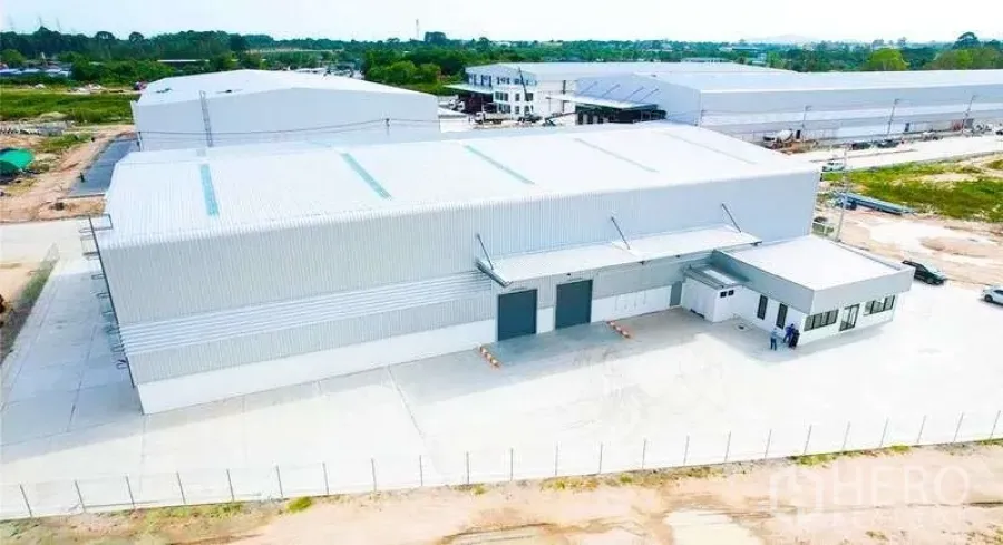 货栈 出租在Mueang Rayong, Rayong - 俯拍：新建金属板仓库，带装卸月台、办公区和围栏混凝土场地