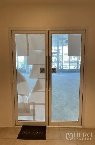 สำนักงาน ให้เช่าในKhlong Toei, Bangkok - ประตูกระจกบานคู่ทางเข้าพื้นที่สำนักงาน พร้อมที่จับแบบดึงและพรมต้อนรับ.