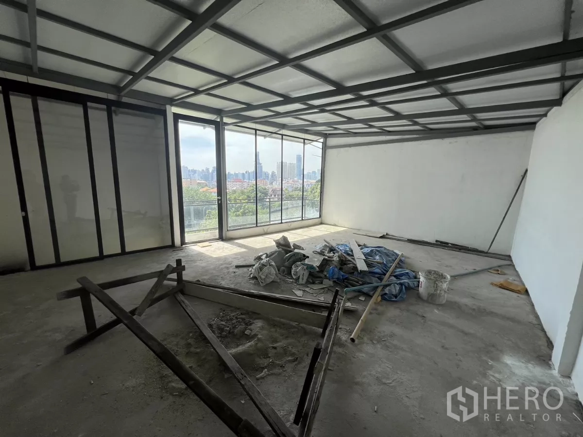 店屋 出售在Suan Luang, Bangkok - 大房间带推拉玻璃门通往阳台，可观城市全景。