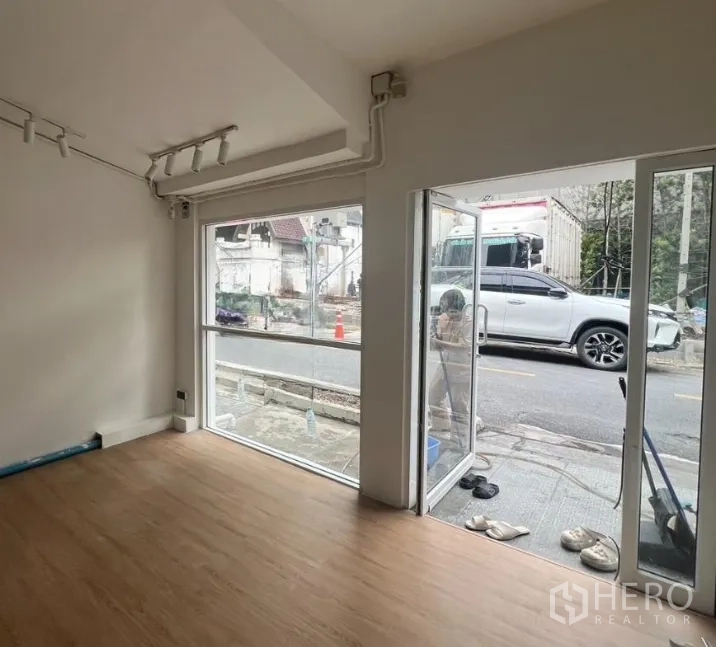 零售空间 出租在Watthana, Bangkok - 店铺转角设有落地玻璃窗与推拉门，直接临街采光充足。