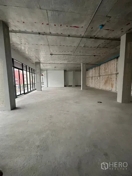 零售空间 出租在Bang Na, Bangkok - 宽敞空置店铺，未完工地面、可见管线与大面积窗墙，临近BTS Udom Suk