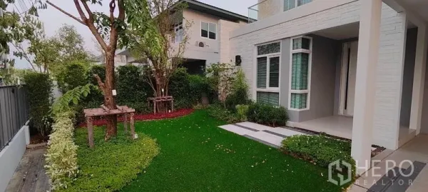 บ้าน ให้เช่าในPrawet, Bangkok - สวนหน้าบ้านจัดแต่งสนามหญ้า ต้นไม้ และระเบียงหน้าบ้านมีหลังคา.