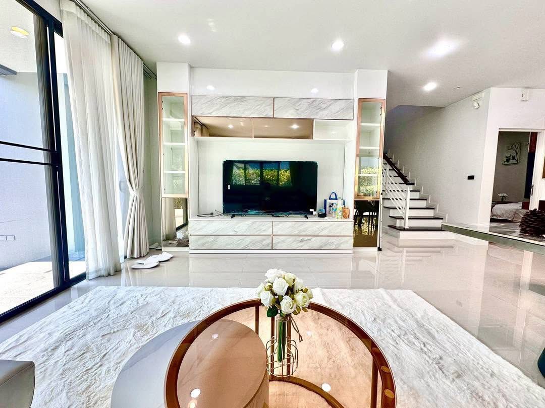 独立式住宅 出租在Bang Kapi, Bangkok - 客厅，巨型电视柜与通往二层的楼梯。