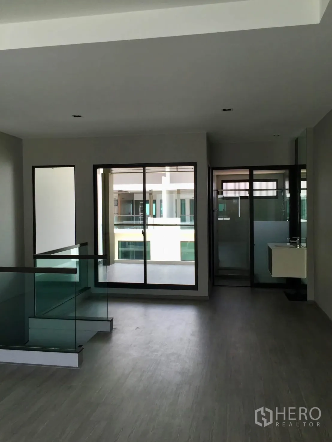 Townhouse for rent in Lat Phrao, Bangkok - Upper landing with glass balustrade opening to balcony and bathroom.