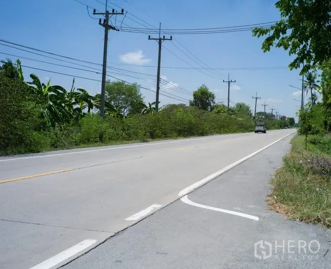工厂 出租在Pathum Thani - 工厂附近的双车道混凝土道路，电力线路与路侧绿化。