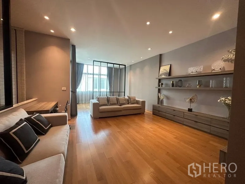 ทาวน์เฮาส์ ขายในSaphan Sung, Bangkok - ห้องนั่งเล่นกว้าง พื้นไม้ ไฟดาวน์ไลท์ โซฟา และชั้นโชว์บิลท์อินยาว