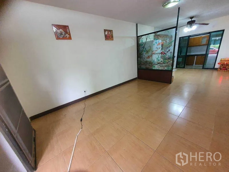 Townhouse for sale in Khlong Toei, Bangkok - Spacious ground-floor living area with tiled floors and a decorative glass partition.