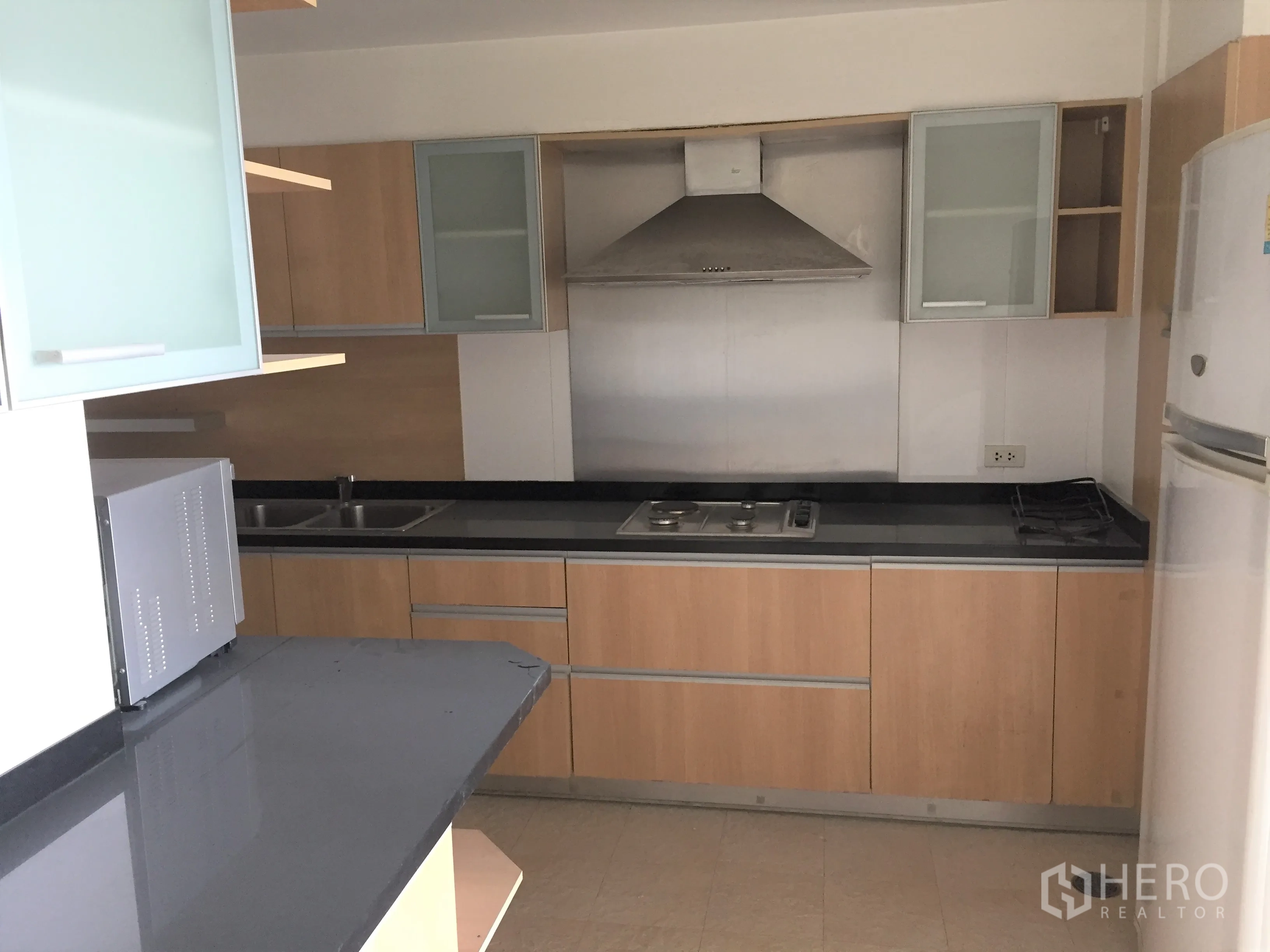 คอนโด ให้เช่าในWatthana, Bangkok - ครัวปิดเคาน์เตอร์หินสีดำ เตาแก๊ส เครื่องดูดควัน อ่างล้างจาน ไมโครเวฟ และตู้เย็น