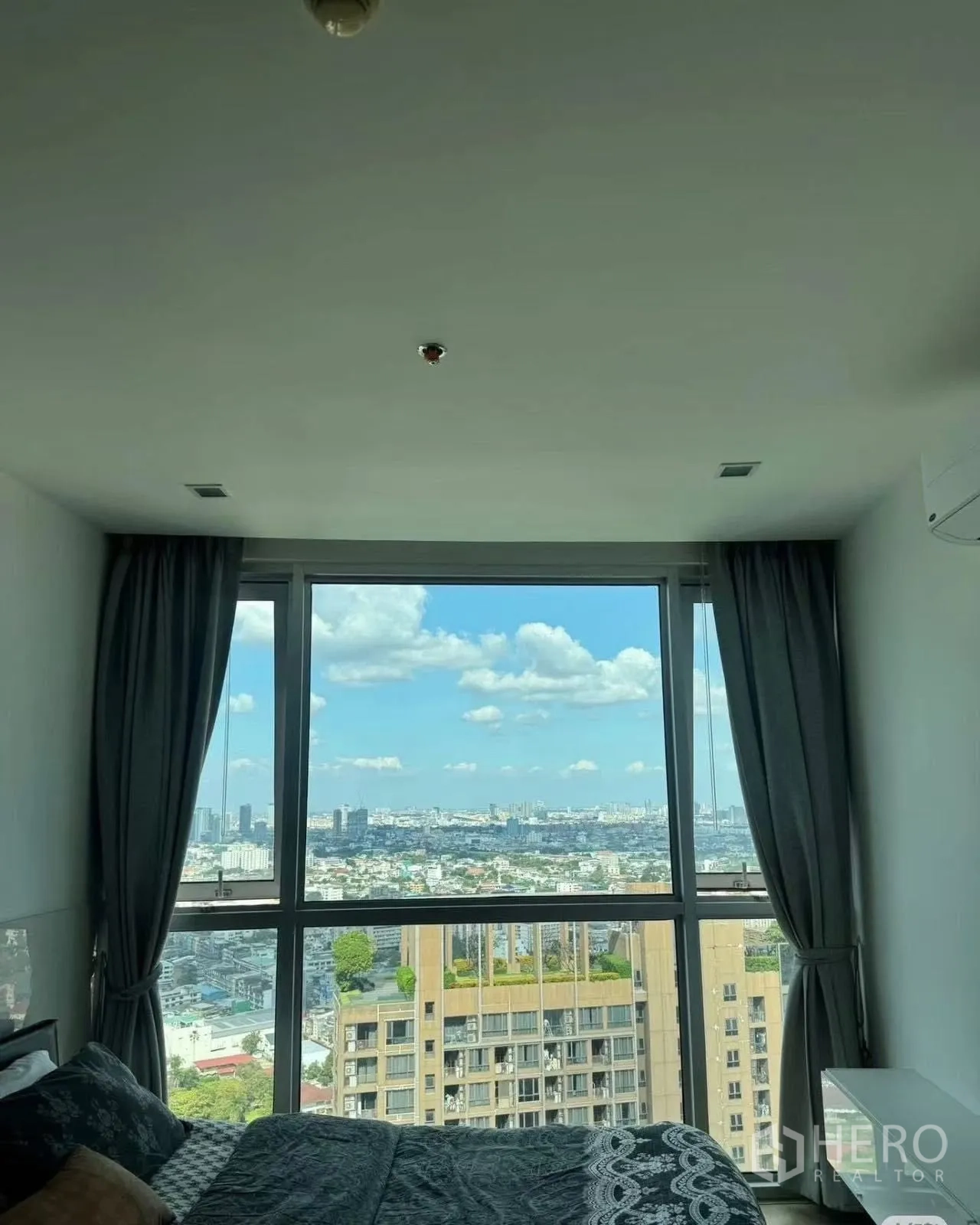 Condominium for rent in Watthana, Bangkok - Bedroom boasting floor-to-ceiling window with expansive city views.
