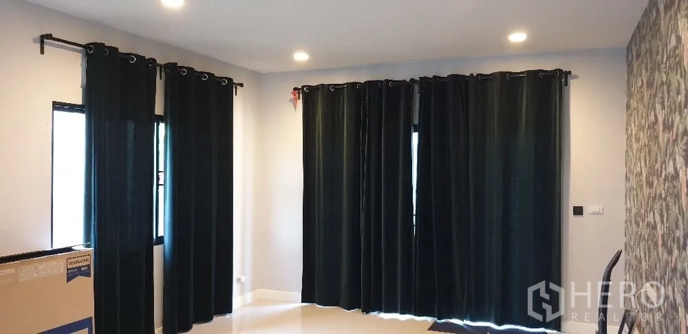 บ้าน ให้เช่าหรือขายในLam Luk Ka, Pathum Thani - ห้องพักผ่อน ผ้าม่านทึบไฟดาวน์ไลต์ และผนังลายกราฟิก