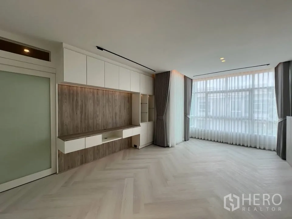 Townhouse for rent in Prawet, Bangkok - Bright living room with floor-to-ceiling windows and wall cabinets.