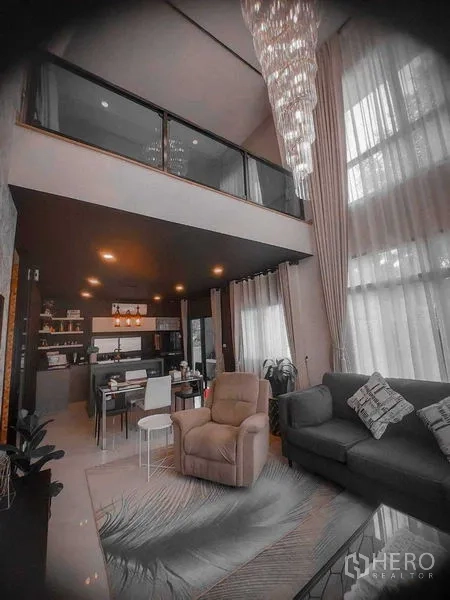 Detached House for rent in Bang Bo, Samut Prakan - Open-plan double-volume living and dining with chandelier and mezzanine.