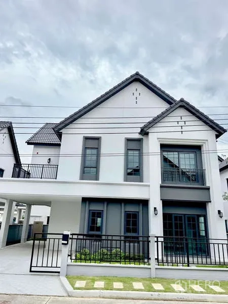 Detached House for sale in Bang Phli, Samut Prakan - Street view of a modern white detached house with balcony and fence.