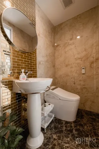 Home Office for sale in Don Mueang, Bangkok - Stylish bathroom with pedestal sink, smart toilet and gold tile accent wall.