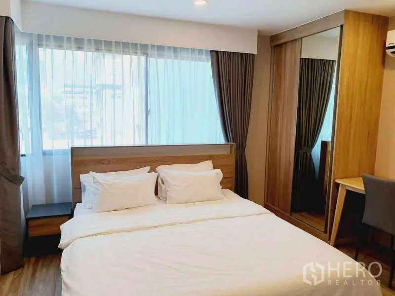 Condominium for rent in Sathon, Bangkok - Bedroom with bed, mirrored wardrobe and study desk by the window.