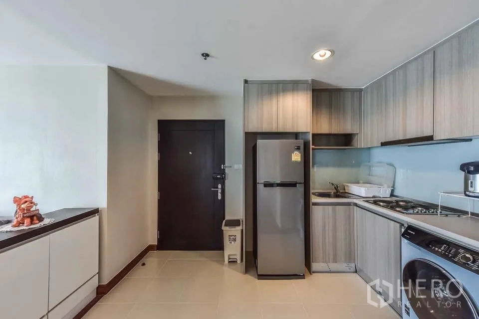 公寓 for rent in Huai Khwang, Bangkok - 厨房配木质橱柜、冰箱、灶台及洗衣机。