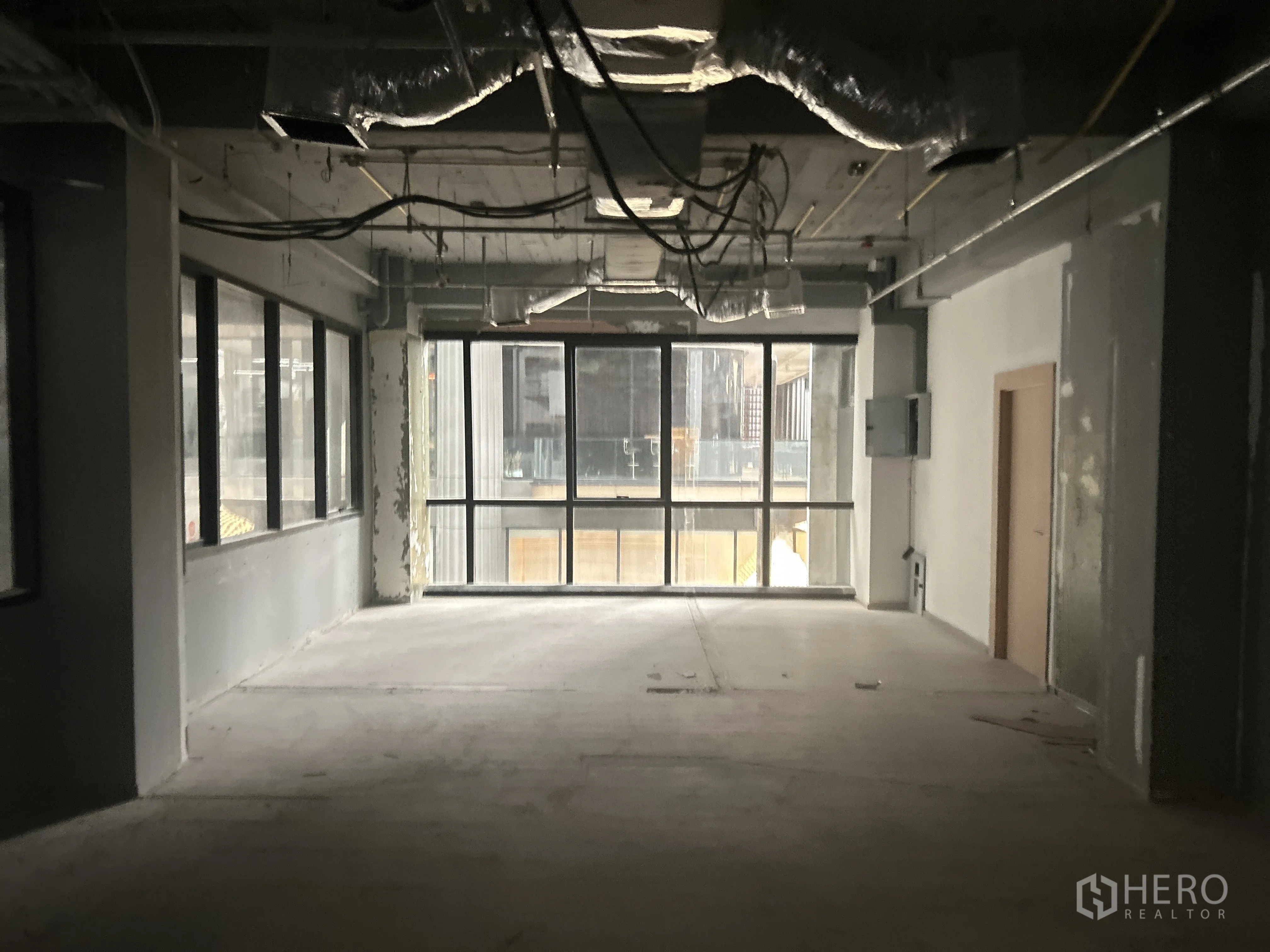 Retail Space for rent in Pathum Wan, Bangkok - Open-plan shop space with exposed services and a large glass window.