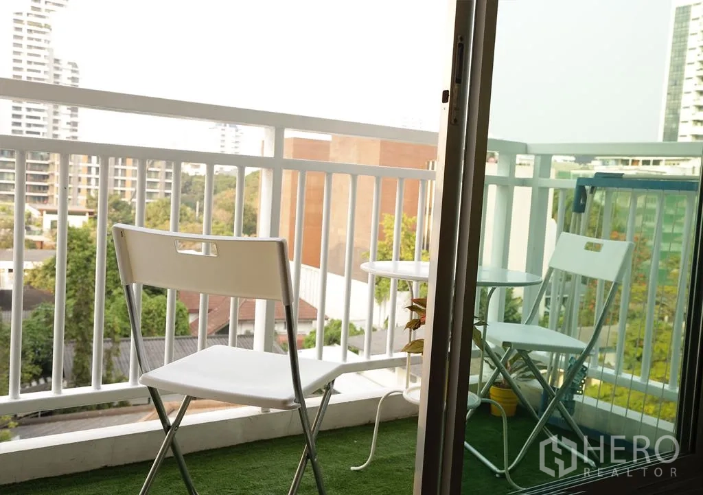 คอนโด ให้เช่าหรือขายในWatthana, Bangkok - ระเบียงส่วนตัวมีเก้าอี้และโต๊ะ มองเห็นวิวเมืองและต้นไม้