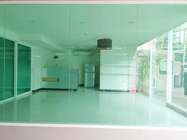 พื้นที่ขายปลีก ให้เช่า - มุมมองภายในร้านผ่านผนังกระจก มีชั้นวาง เคาน์เตอร์ และต้นไม้