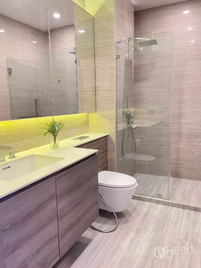 Condominium for rent in Phra Khanong, Bangkok - Contemporary bathroom with glass shower, backlit mirror and floating vanity.