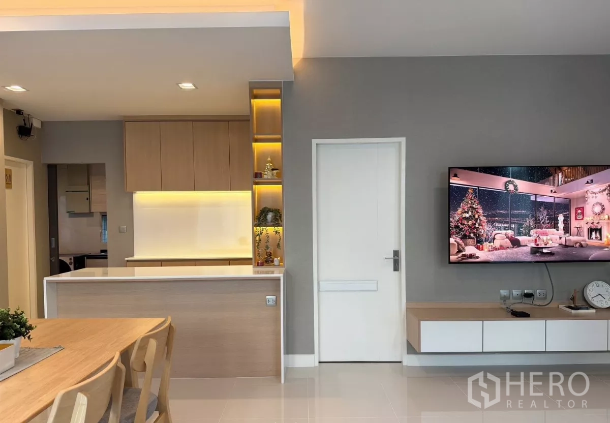 Detached House for rent in Prawet, Bangkok - Built-in media wall and warm-lit shelving next to compact kitchen counter