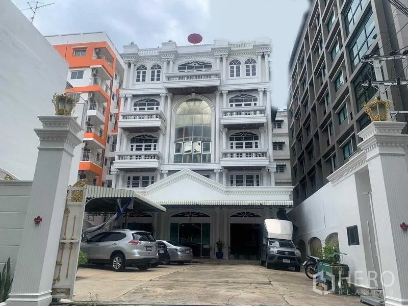 สำนักงาน ให้เช่าในKhlong San, Bangkok - ด้านหน้าตึกสำนักงานพร้อมซุ้มทางเข้า ลานจอดรถ และอาคารโดยรอบ