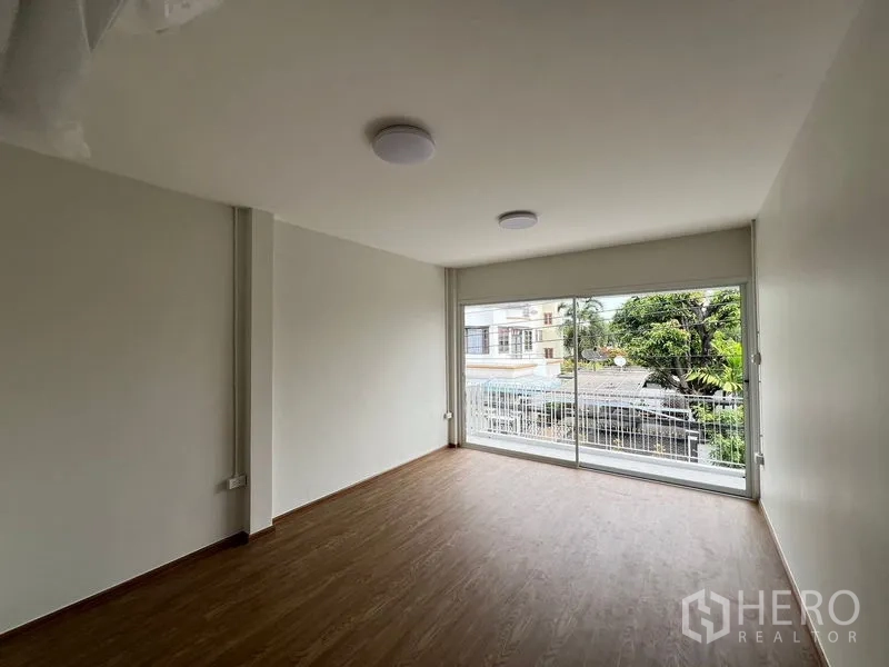 สำนักงานที่บ้าน ให้เช่าในHuai Khwang, Bangkok - ห้องนอนพร้อมหน้าต่างเต็มผนังและราวระเบียง มองเห็นต้นไม้ด้านหน้า