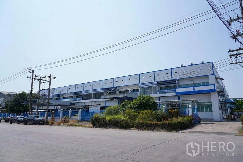 Factory for rent in Bang Sao Thong, Samut Prakan - Street view of a modern blue‑and‑white industrial complex.