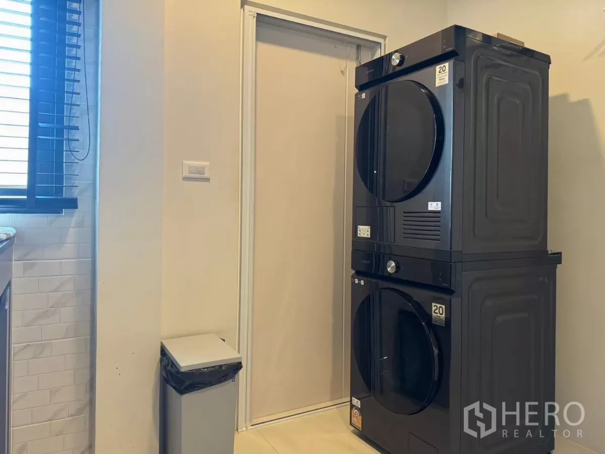 Detached House for rent in Bang Phli, Samut Prakan - Laundry area with stacked washer and dryer beside window.