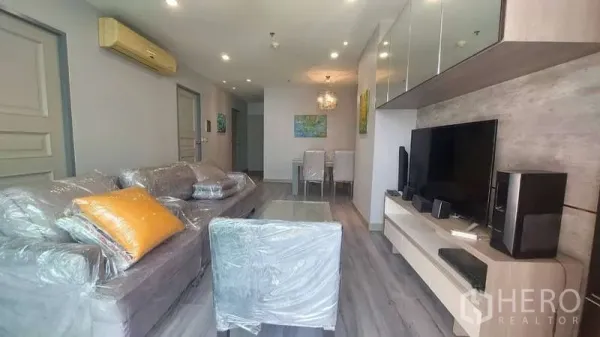 คอนโด ให้เช่าในWatthana, Bangkok - ห้องนั่งเล่นมีโซฟา ชั้นวางทีวี และผนังกระจกเงา ในเขตวัฒนา กรุงเทพฯ