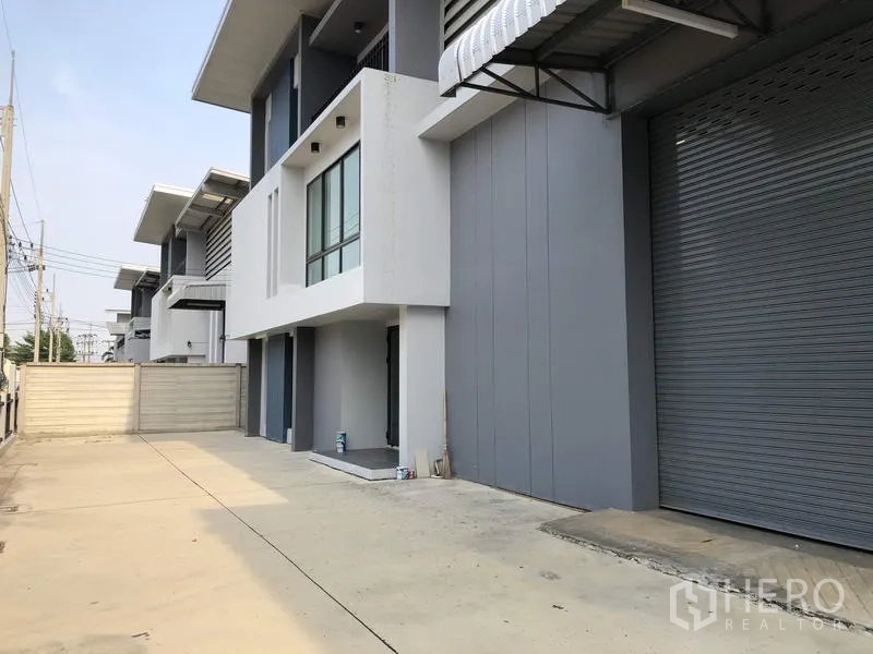 工厂 出租或出售在Pathum Thani - 一排现代单位，卷闸门与混凝土车道。