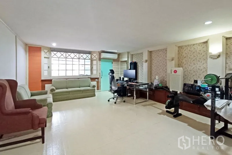 公寓 出售在Bangkok - 多功能家庭房，沙发、家用办公桌与健身凳配置。