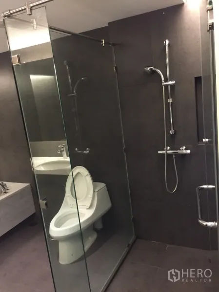 คอนโด ให้เช่าในWatthana, Bangkok - ห้องน้ำสไตล์โมเดิร์นพร้อมตู้กระจกอาบน้ำ ฝักบัวแบบสาย และกระเบื้องสีเข้ม