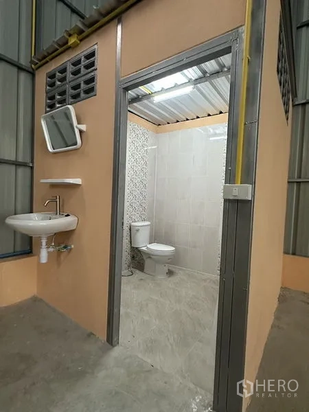 货栈 出租在Bueng Kum, Bangkok - 仓库内洁净卫生间，配马桶、瓷砖墙面与洗手盆。