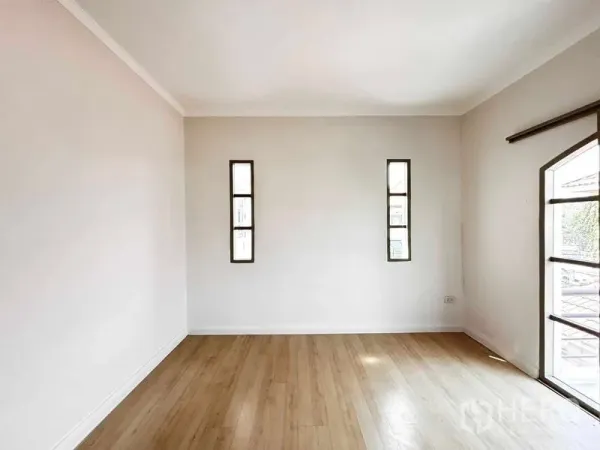 Detached House for rent or sale - Empty room with light wood flooring and slim vertical windows for natural light.