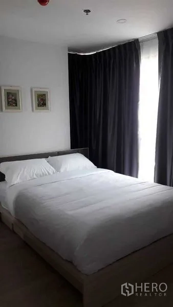 คอนโด ให้เช่าในBang Na, Bangkok - ห้องนอนหลักเตียงคู่ ชุดผ้าปูสีขาว พร้อมผ้าม่านทึบในคอนโดย่านบางนา.