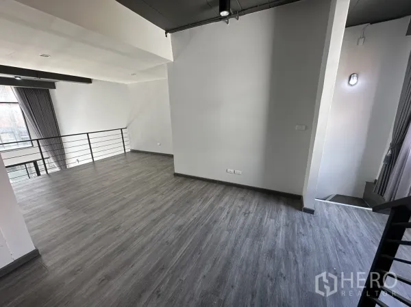 带办公室的家 出租或出售在Suan Luang, Bangkok - 夹层空间宽敞，灰色木纹地板与金属栏杆，配大窗采光。