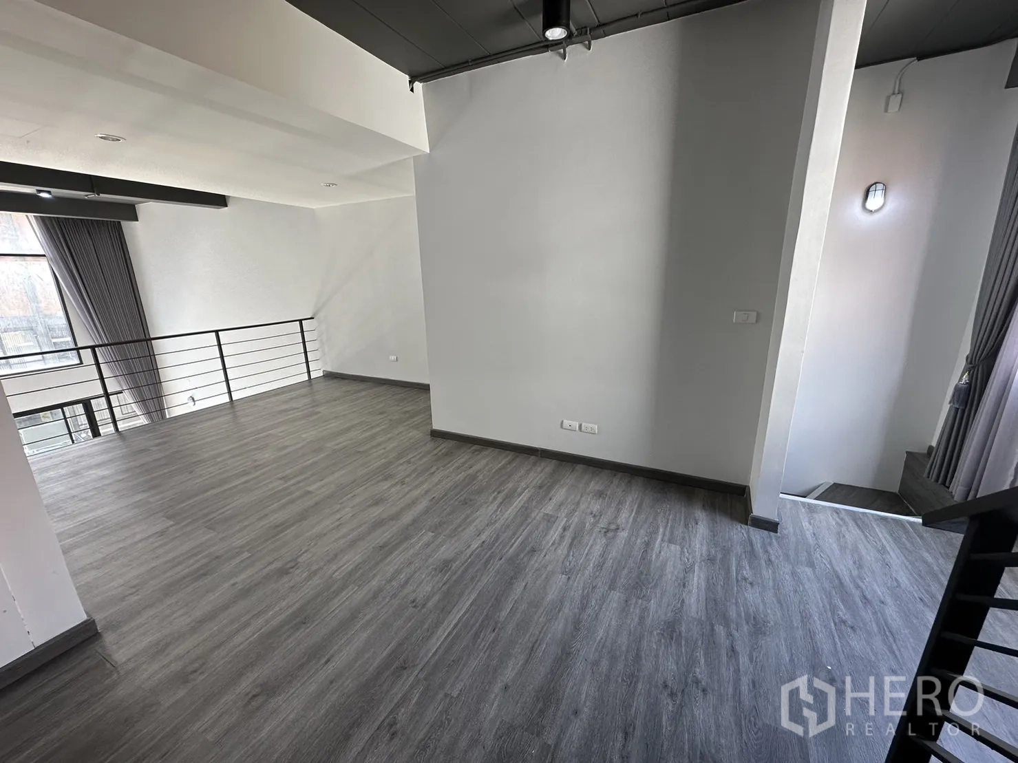 带办公室的家 出租或出售在Suan Luang, Bangkok - 夹层空间宽敞，灰色木纹地板与金属栏杆，配大窗采光。