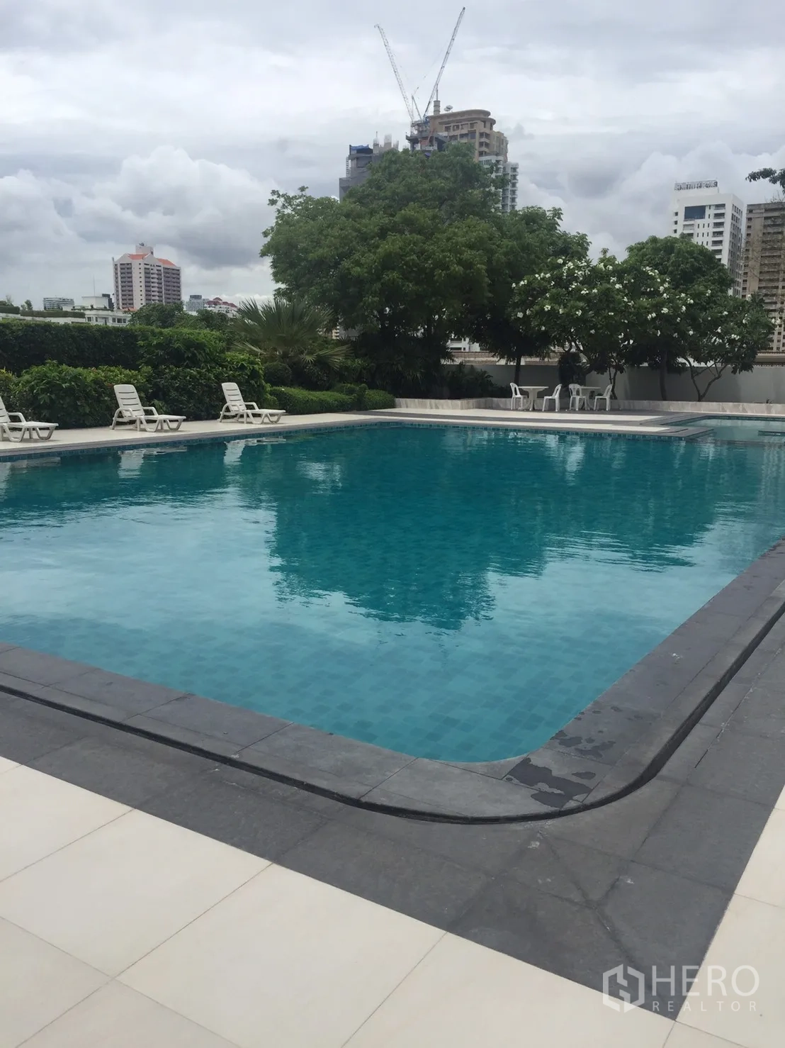 Condominium for rent in Watthana, Bangkok - Outdoor swimming pool with sun loungers, city views and landscaped greenery.