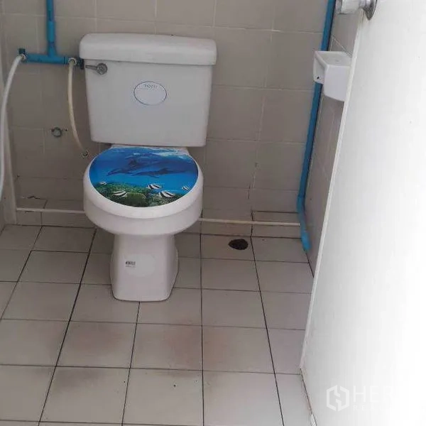 Warehouse for rent in Bang Sue, Bangkok - Clean tiled restroom inside the warehouse with toilet and small basin.