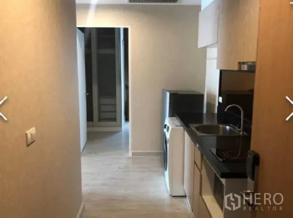 公寓 出租在Watthana, Bangkok - 一字型厨房，黑色台面、水槽、吊柜与洗衣机