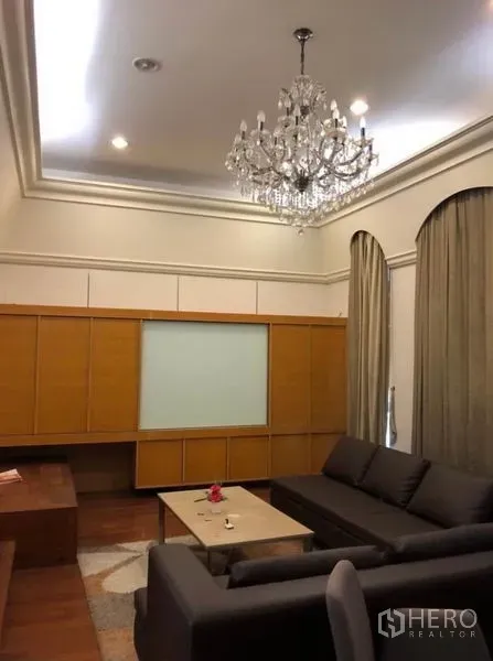 ทาวน์เฮาส์ ให้เช่าในChatuchak, Bangkok - ห้องนั่งเล่นติดโคมระย้า โซฟาเข้ามุม ตู้บิลท์อินไม้ และผ้าม่านสูงแตะเพดาน