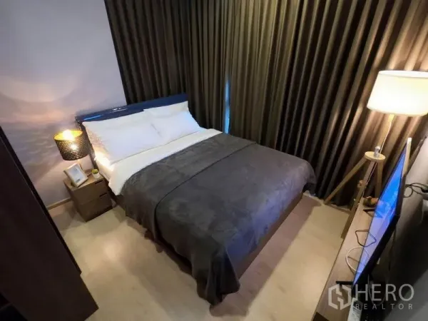 คอนโด ให้เช่าหรือขายในWatthana, Bangkok - ห้องนอนที่สองขนาดกะทัดรัด เตียงคู่ ผ้าม่านทึบแสง และโคมไฟหัวเตียง