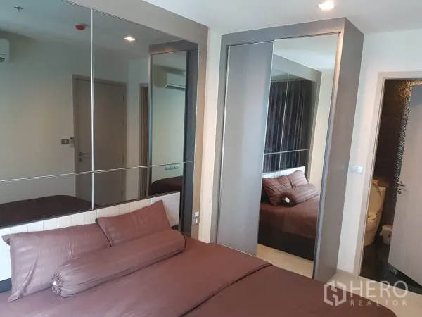 คอนโด ให้เช่าในKhlong Toei, Bangkok - ห้องนอนโทนสีน้ำตาล มีผนังกระจกและตู้เสื้อผ้าบานเลื่อน