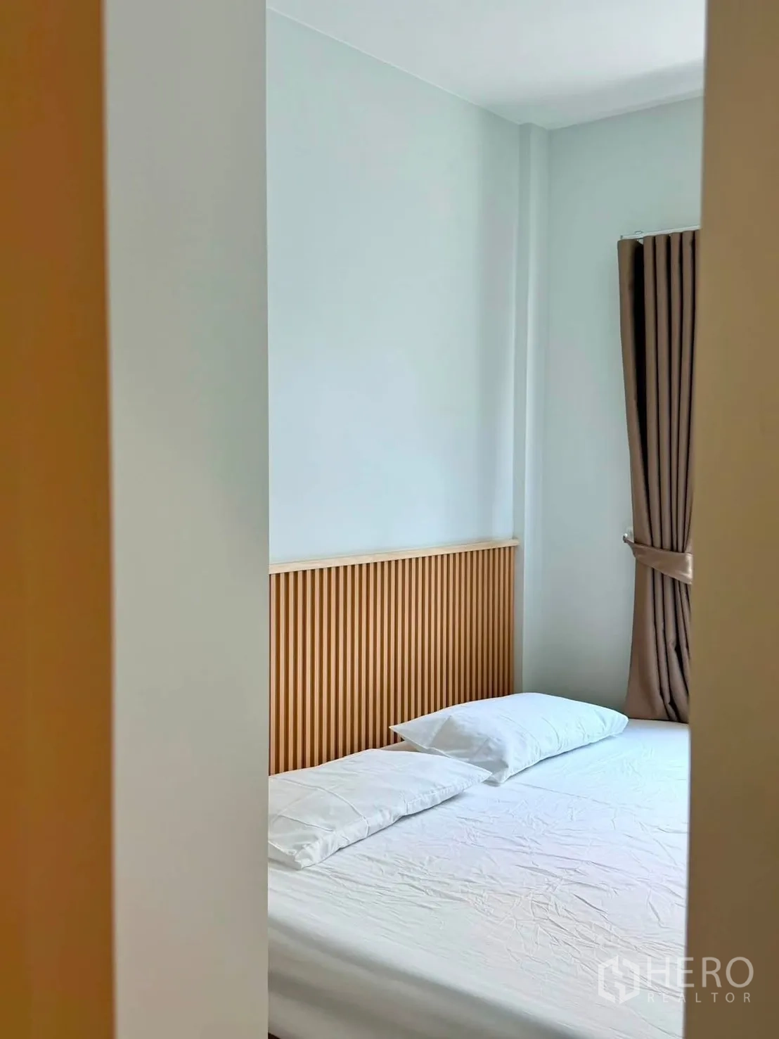 Townhouse for rent in Bang Phli, Samut Prakan - Bright bedroom angle showing a bed and window with brown drapes.