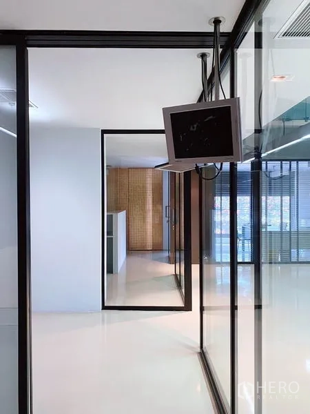 Office Space for rent in Phaya Thai, Bangkok - Glass-walled corridor with black frames and a suspended monitor leading to meeting or private rooms.