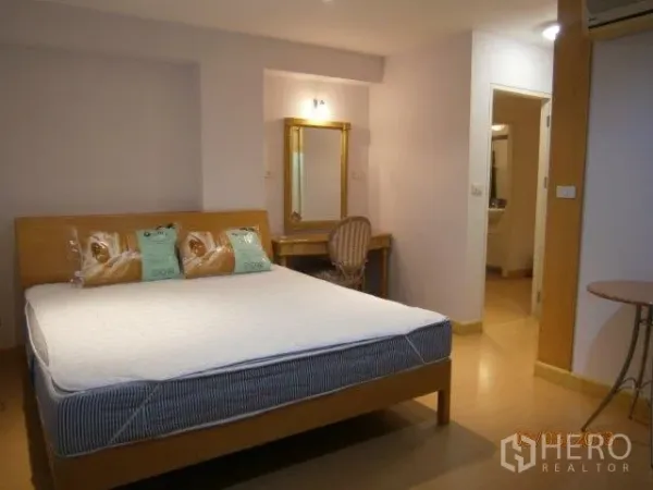 คอนโด ให้เช่าในKhlong Toei, Bangkok - ห้องนอนหลักสว่าง เตียงไม้ โต๊ะเครื่องแป้งพร้อมกระจก และประตูเข้าสู่ห้องน้ำ