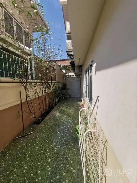 ทาวน์เฮาส์ ให้เช่าในChatuchak, Bangkok - ทางเดินข้างบ้านแคบปูพื้นกระเบื้อง มีแปลงต้นไม้ริมกำแพง.